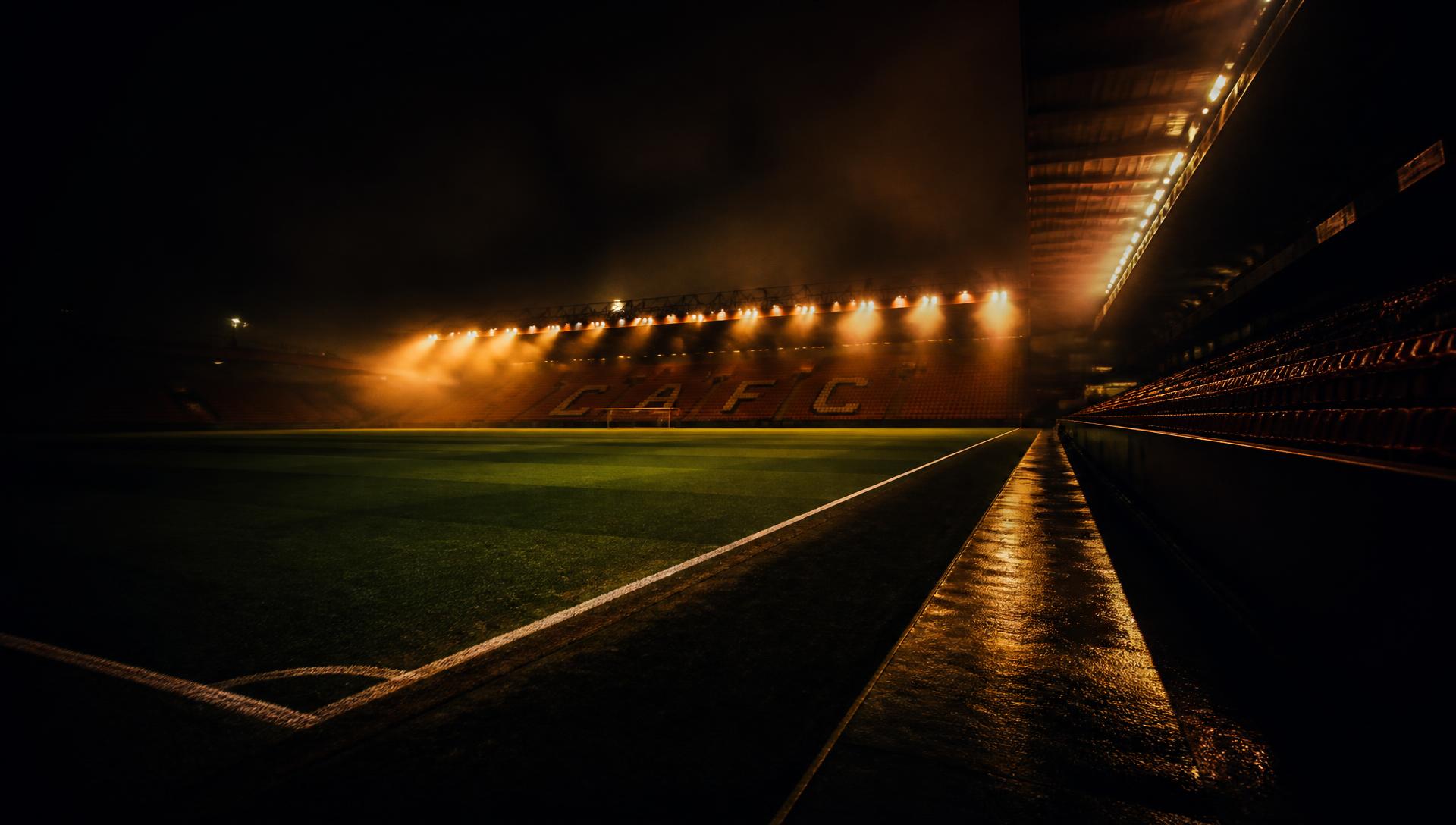 Pelouse éclairée par les projecteurs d'un stade la nuit